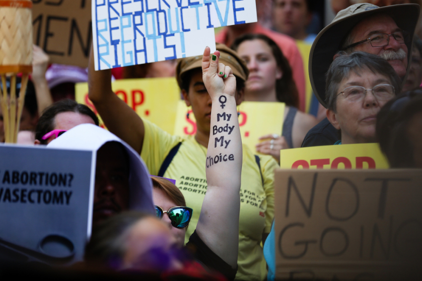 Melissa Simpson snaps her fingers in support of a speaker during a protest against recently passed abortion ban bills at the Georgia State Capitol building, on May 21, 2019 in Atlanta, Georgia.