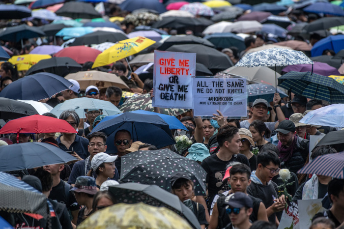 Protesters hold placards as they prepare to demonstrate against the now-suspended extradition bill on June 16, 2019 in Hong Kong. 