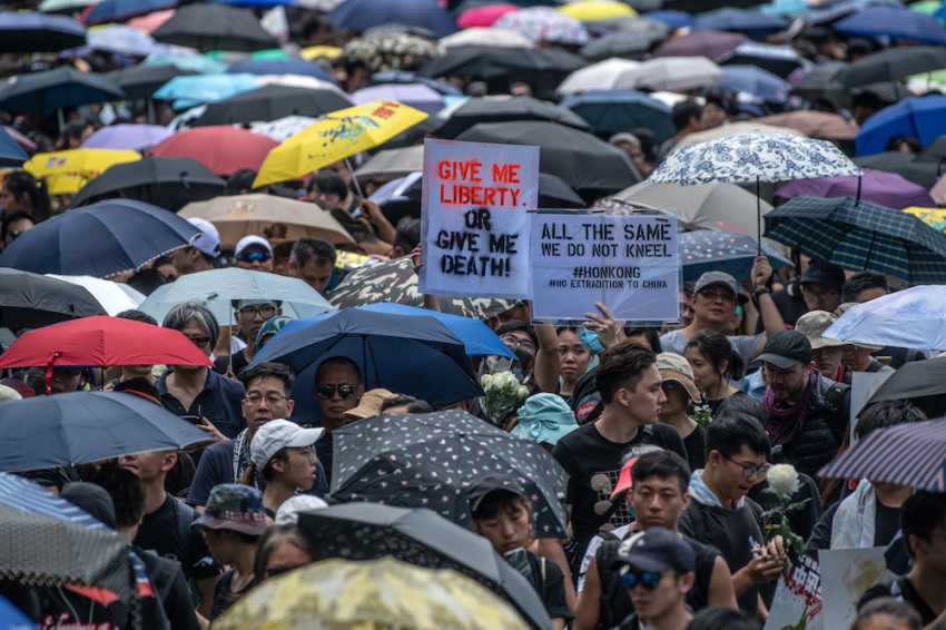 Protesters hold placards as they prepare to demonstrate against the now-suspended extradition bill on June 16, 2019 in Hong Kong.