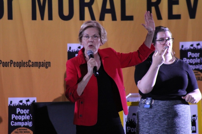 Massachusetts Democrat Sen. Elizabeth Warren, accompanied by a sign language translator, speaks at the Poor People's Campaign Moral Action Congress held at Trinity Washington University in Washington, D.C. on June 17, 2019.