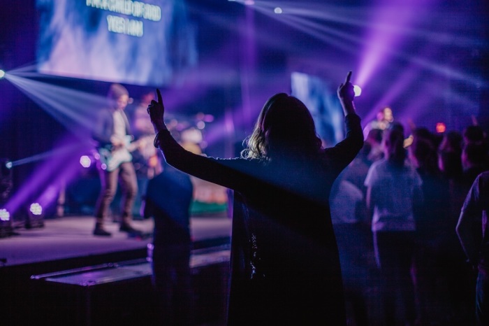 An attendee of a Kingdom Youth Conference event at Destiny Life Church in Claremore, Oklahoma in April 2019 raises her hands in worship. 