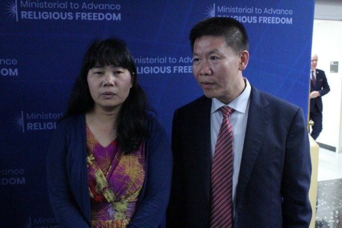Manping Ouyang (L), a Chinese Christian who belongs to the Living Stone Church in Guiyang, speaks with reporters during the U.S. State Department's Ministerial to Advance Religious Freedom at the Harry S. Truman Building in Washington, D.C. Her remarks were translated by Bob Fu (R) of China Aid. 