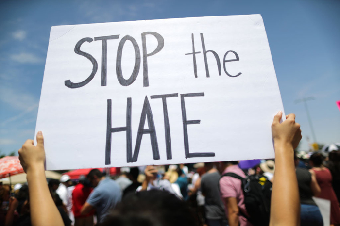 A demonstrator holds a sign reading 'Stop the Hate' at a protest against President Trump's visit following a mass shooting, which left at least 22 people dead, on August 7, 2019 in El Paso, Texas. 