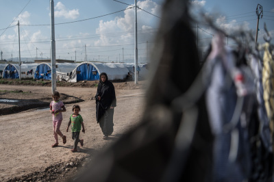 A woman and children walk through Khazir refugee camp on April 15, 2017 near Mosul, Iraq. 