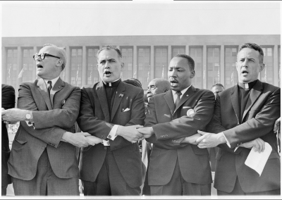 Rev. Hesburgh standing side by side with Martin Luther King fighting for equality in America.