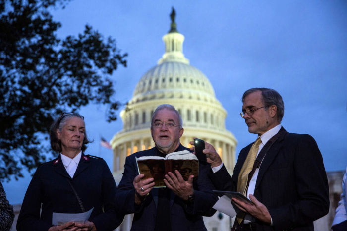 The Rev. Jim Wallis (C) leads a prayer in front of the Capitol Building in Washington, D.C., on the morning of Oct. 16, 2013. 