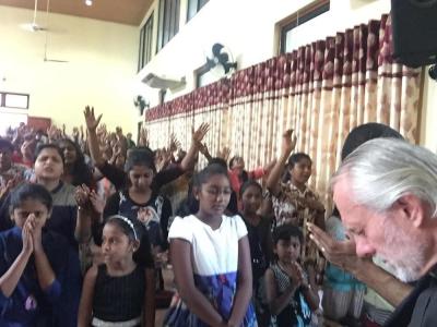 William Devlin (R) prays with congregants of Zion Church in Sri Lanka, 2019.