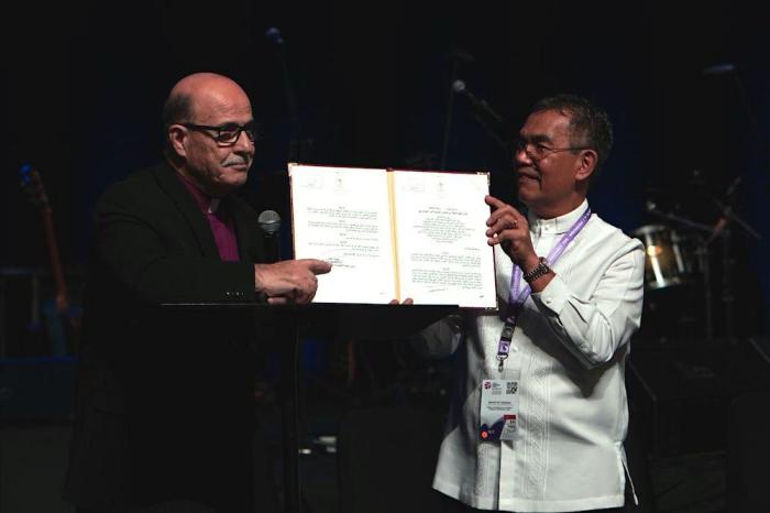 Munir Salim Kakish, president of the Council of Local Evangelical Churches in the Holy Land (left), and Bishop Efraim Tendero, secretary general of the World Evangelical Alliance (right), hold up document of Palestinian Authority giving Kakish's group legal recognition in the West Bank. 