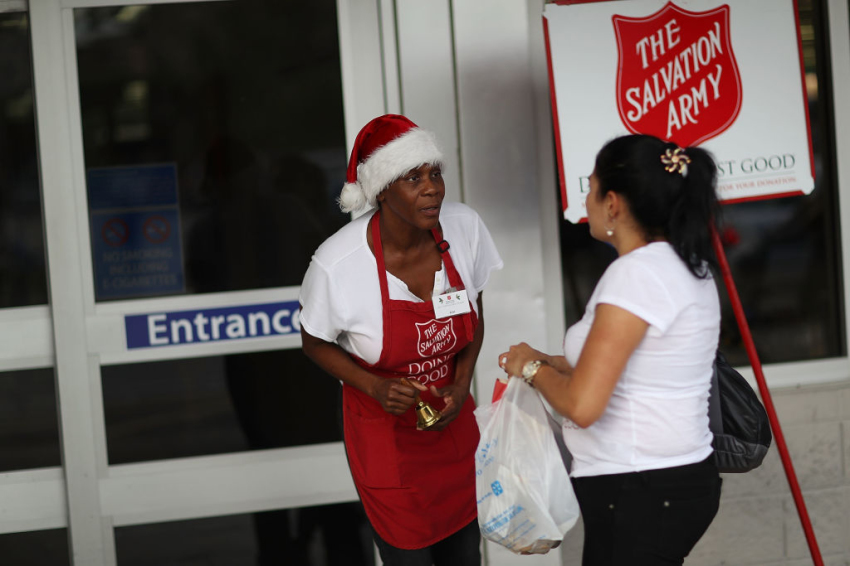 Kim Simmons, a bellringer for the Salvation Army, greets people as she collects donations in her red kettle on Giving Tuesday on November 28, 2017, in Hallandale, Florida.
