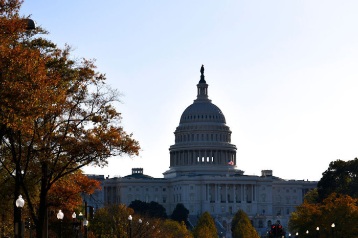 Morning light illuminates an American flag flying at the U.S. Capitol Building on November 13, 2019, in Washington, D.C.
