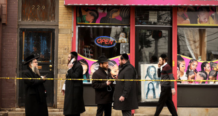 Members of the Jewish community pass by near the scene of a mass shooting at the JC Kosher Supermarket on December 11, 2019, in Jersey City, New Jersey. Six people, including a Jersey City police officer and three civilians were killed in a deadly, hours-long gun battle between two armed suspects and police on Tuesday in a standoff and shootout in a Jewish market that appears to have been targeted, according to Jersey City Mayor Steven Fulop.