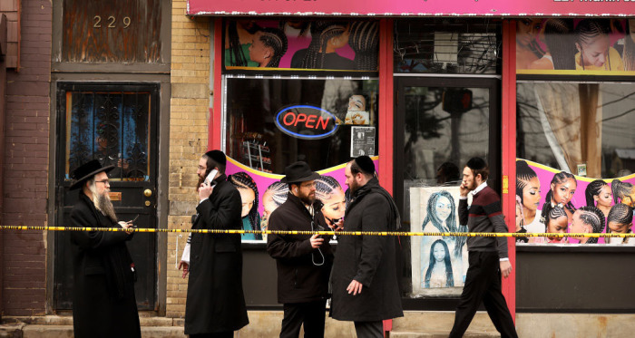 Members of the Jewish community pass by near the scene of a mass shooting at the JC Kosher Supermarket on December 11, 2019, in Jersey City, New Jersey. Six people, including a Jersey City police officer and three civilians, were killed in a deadly, hours-long gun battle between two armed suspects and police on Tuesday in a standoff and shootout in a Jewish market that appears to have been targeted, according to Jersey City Mayor Steven Fulop. 