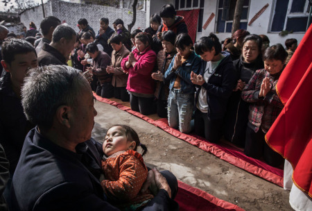 A Chinese Catholic worshipers wait to take communion at the Palm Sunday Mass during the Easter Holy Week at an