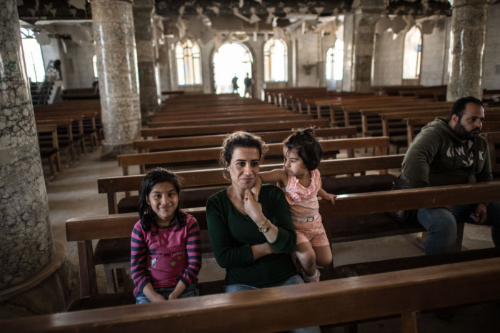  A woman and her children attend an Easter ceremony in Saint John's Church (Mar Yohanna) in the nearly deserted predominantly Christian Iraqi town of Qaraqosh on April 16, 2017, near Mosul, Iraq. 