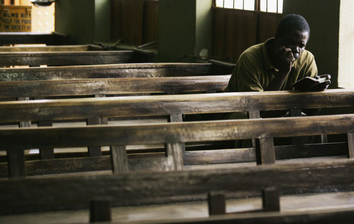 A Nigerian worshiper reads through his Bible after other parish members have left April 12, 2005, in Kano, Nigeria. Kano is part of Nigeria's primarily Muslim north, but devoted Catholic minority participates in frequent Masses in local cathedrals. 