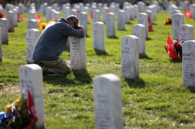 Chris Plank of Maryland holds the headstone of his friend Army Sgm. Bradly Dean Conner, who was killed in Iraq, at Section 60 at Arlington National Cemetery on Veterans Day November 11, 2019, in Arlington, Virginia. Americans observed Veterans Day to honor those who had served in the U.S. military. 