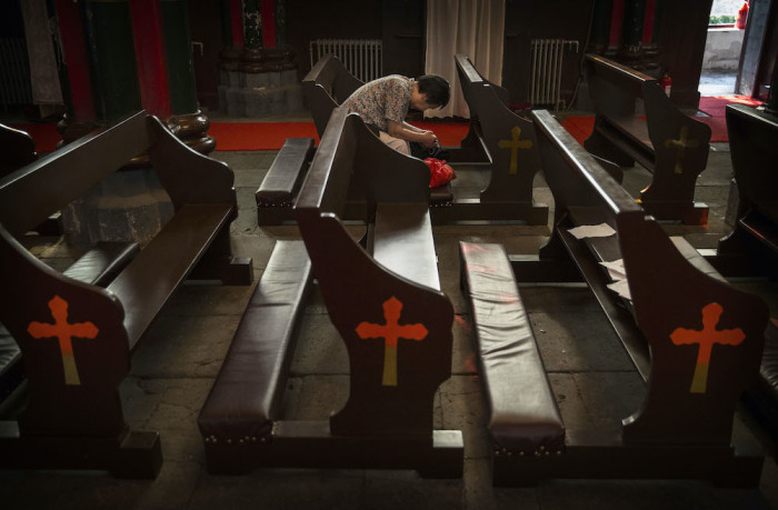 A Chinese Catholic woman prays at the government sanctioned Xishiku Catholic Church on August 14, 2014 in Beijing, China. 