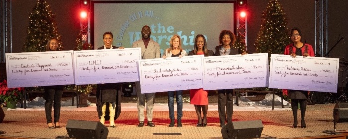Leaders with nonprofit organizations hold up ,000 checks given to them by The Worship Center Christian Church during a Dec. 23, 2019 service. They are joined on stage by Bishop Van Moody. 