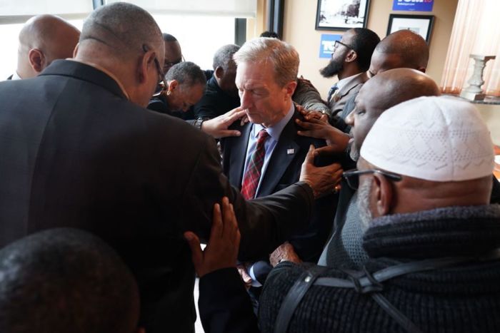 African American clergy, activists, and community leaders who pray over Democratic presidential candidate Tom Steyer and his campaign in Des Moines, Iowa.