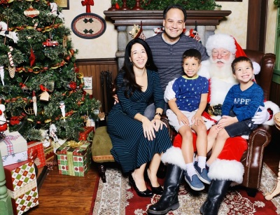 Rachel and Ricardo Bruno, along with their two sons, pose for a photograph with Santa Claus. 