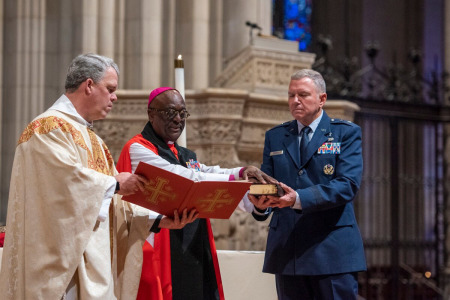 The Very Rev. Randolph Hollerith, dean of the Washington National Cathedral, left, and the Right Rev. Carl Wright, bishop suffragan for the U.S. Armed Forces and federal ministries in the Episcopal Church, center, bless the official Bible of the newly created Space Force during a service at the cathedral on Jan. 12, 2020. Maj. Gen. Steven Schaick, the Air Force's chief of chaplains, is holding the Bible on the right.