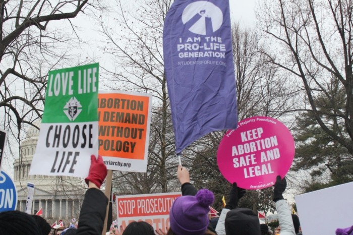 Pro-life and pro-choice demonstrators hold up signs outside of the U.S. Supreme Court in Washington, D.C. during the March for Life on Jan. 24. 2020. 