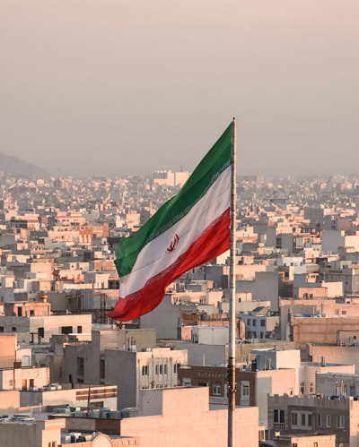 Iranian flag waving with cityscape on background in Tehran, Iran