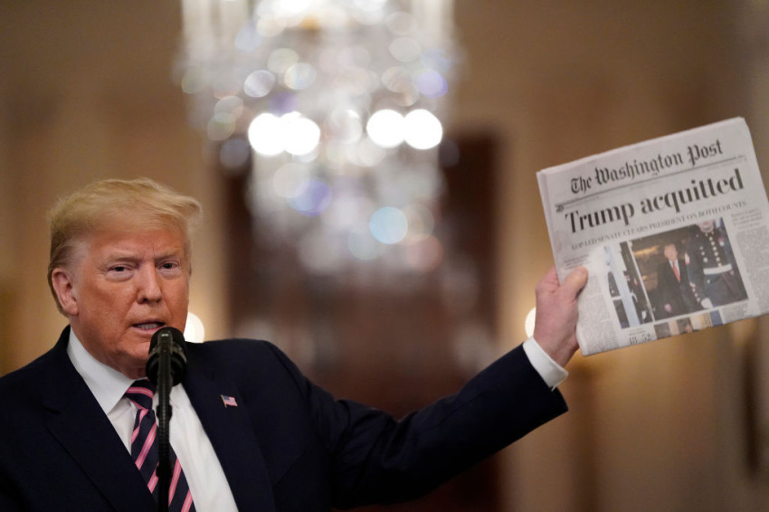 President Donald Trump holds a copy of The Washington Post as he speaks in the East Room of the White House one day after the U.S. Senate acquitted him on two articles of impeachment brought by Democrats in the House without bipartisan support, on February 6, 2020, in Washington, D.C.