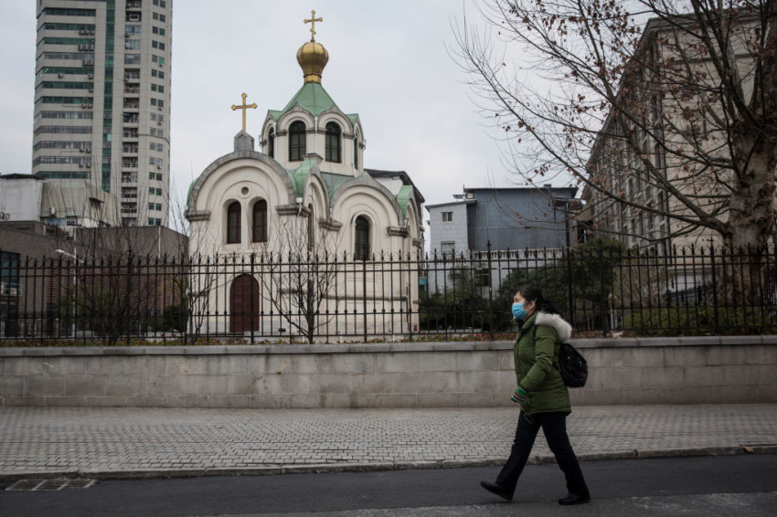 A woman wears a protective mask as she passes a church on February 8, 2020, in Wuhan, Hubei province, China. 
