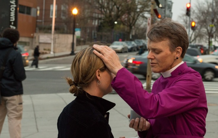 Bishop Mariann Edgar Budde, head of the Episcopal Diocese of Washington, imposing ashes on a person as part of the 'Ashes to Go' observance on Ash Wednesday, 2017. 