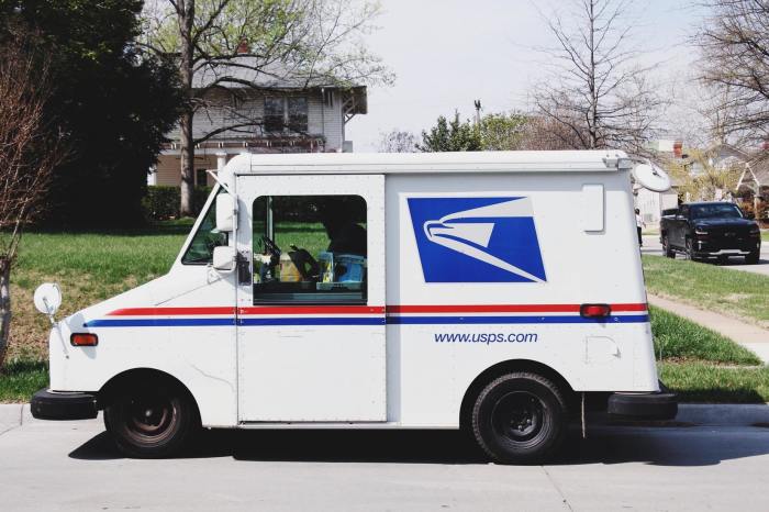 A mail truck sits parked on the side of the street.