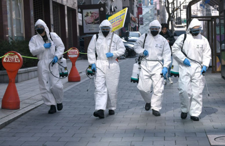 South Korean soldiers wearing protective gear spray disinfectant on the street to help prevent the spread of the COVID-19 coronavirus, at Gangnam district in Seoul on March 5, 2020. South Korea's total number of novel coronavirus cases -- the largest outside China, where the disease first emerged -- approached 6,000 on March 5 as authorities reported 145 new infections.