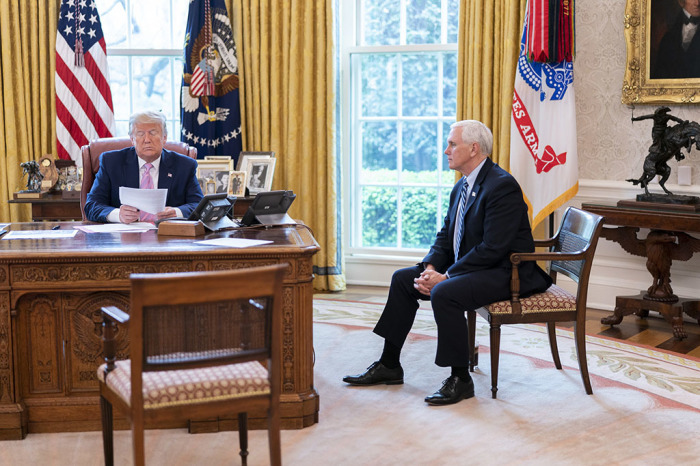 President Donald J. Trump, joined by Vice President Mike Pence, use the speaker phone to talk with military family members in the Oval Office of the White House Wednesday, April 1, 2020, during a conference call town hall to discuss the military response to the coronavirus (COVID-19) outbreak. 