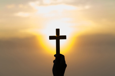 Silhouette of a cross against the sky during sunset. 