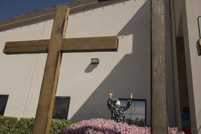 An attendee raises his hands to the sky during a drive-in Easter service amid the Coronavirus pandemic at the International Church of Las Vegas in Las Vegas, Nevada, on Sunday, April 12, 2020.
