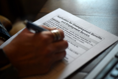 In this photo illustration, a person files an application for unemployment benefits on April 16, 2020, in Arlington, Virginia. 