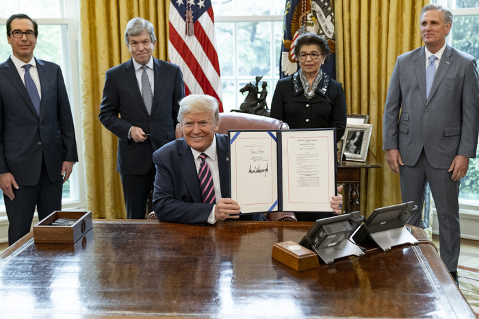 President Donald J. Trump displays his signature on H.R. 266, the Paycheck Protection Program and Health Care Enhancement Act Friday, April 24, 2020, joined by from left to right Secretary of the Treasury Steven Mnuchin, Sen. Roy Blunt, R-Mo., Administrator of the U.S. Small Business Administration Jovita Carranza and House Minority Leader Rep. Kevin McCarthy, R-Calif., in the Oval Office of the White House. 