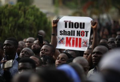 Christians hold signs as they march on the streets of Abuja during a prayer and penance for peace and security in Nigeria in Abuja on March 1, 2020.  