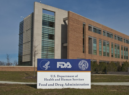 FDA Building 21 stands behind the sign at the campus's main entrance and houses the Center for Drug Evaluation and Research. The FDA campus is located in Silver Spring, Maryland.