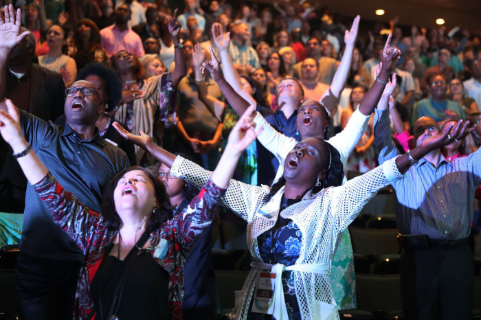 Parishioners of Lakewood Church led by Pastor Joel Osteen pray together during a service at the church in Houston, Texas, on September 3, 2017.