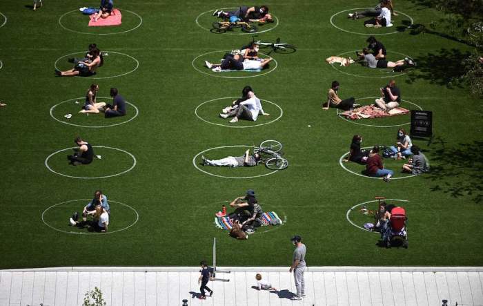 People are seen practicing social distancing in white circles in Domino Park during the COVID-19 pandemic on May 17, 2020, in the Brooklyn borough of New York City. 