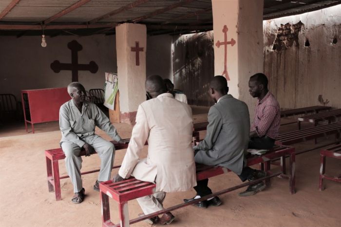 Lutheran reverend Yousef Zamgila (L) speaks to members of his congregation at the small improvised church they helped set up in a neighbours yard in Omdurman, Khartoums twin city, on August 22, 2019. Sudan's Christians suffered decades of persecution under the regime of Islamist general Omar al-Bashir. 