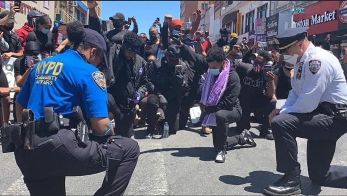 New York City police officers join Pastor Garelle K. Solomon (Purple Scarf) and The Excelling Church in protest on May 31, 2020.