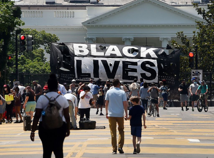 A 'Black Lives Matter' banner hangs on the fence erected around the White House to protest the death of George Floyd in Washington, D.C., on June 10, 2020. 