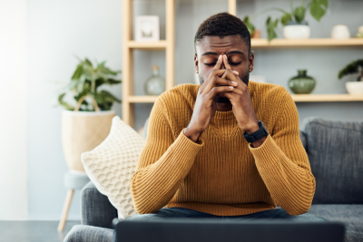 Shot of a young man looking stressed out at home.