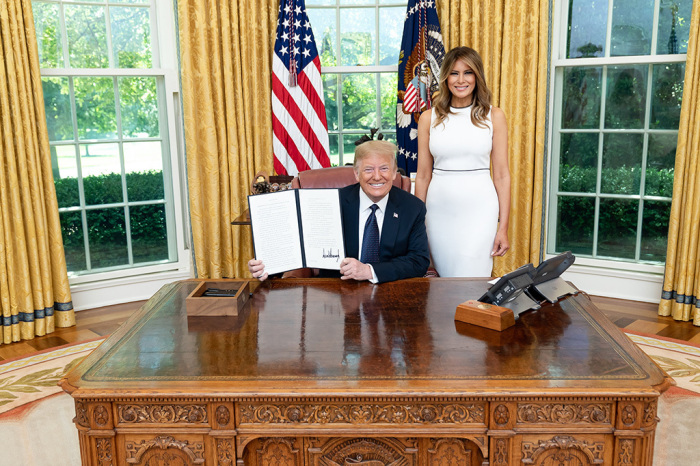 President Donald J. Trump, joined by First Lady Melania Trump, as he displays his signature after signing an executive order on strengthening the child welfare system for America’s children Wednesday, June 24, 2020, in the Oval Office of the White House. 