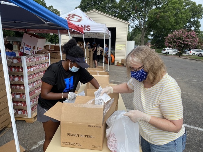 Zoey Daniels (left) and Shan Fite (right) package peanut butter for food distribution at Eastside Community Church in Memphis, Tennessee, on July 15, 2020.