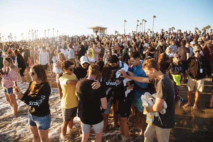People pray and join Saturate OC at Huntington Beach, California, July 2020.