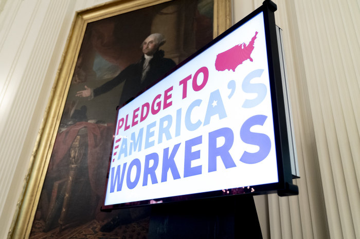 A video display announces a Pledge to America’s Workers under the painting of George Washington during the American Workforce policy advisory board meeting Friday, June 26, 2020, in the East Room of the White House. 