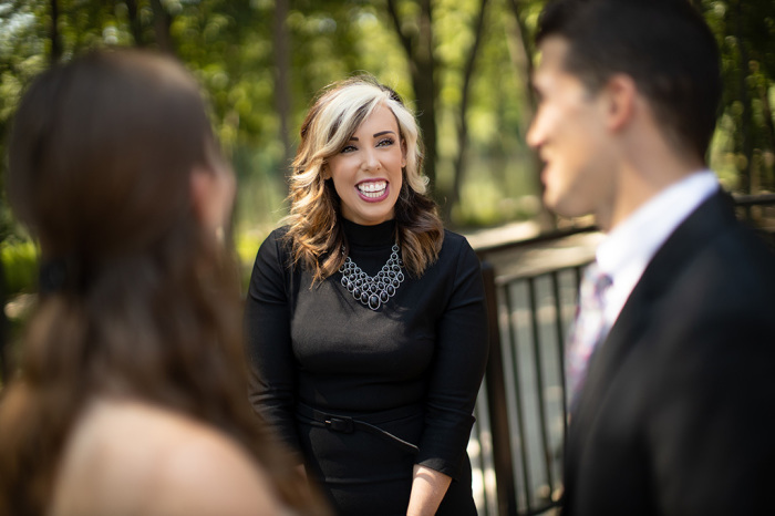 Kristi Stokes (center), owner of Covenant Weddings in Cuyahoga County, Ohio, interacting with a bride and groom at a wedding photo shoot.